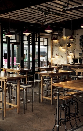 High timber tables soften the industrial aesthetic.